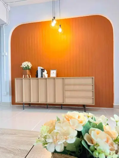 Stylish living room with modern wooden cabinet and vibrant orange accent wall