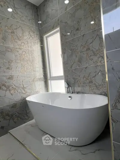 Luxurious bathroom with elegant freestanding bathtub and marble walls
