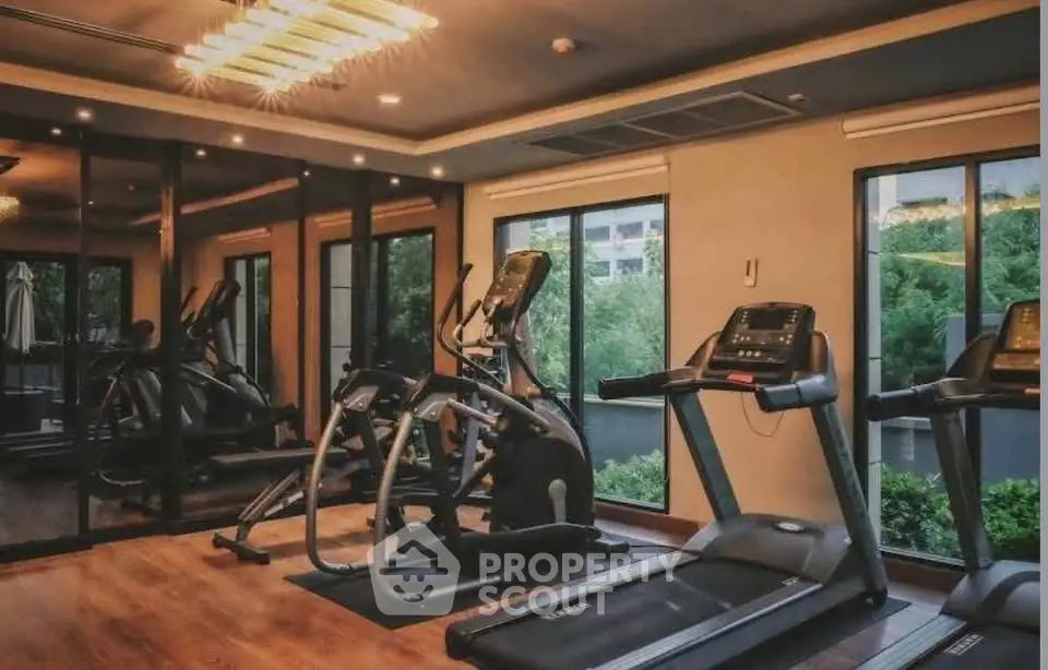 Luxurious home gym with modern equipment and large windows offering scenic views.