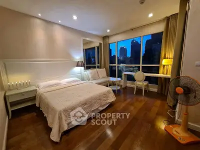 Luxurious bedroom with city view, elegant decor, and hardwood floors.