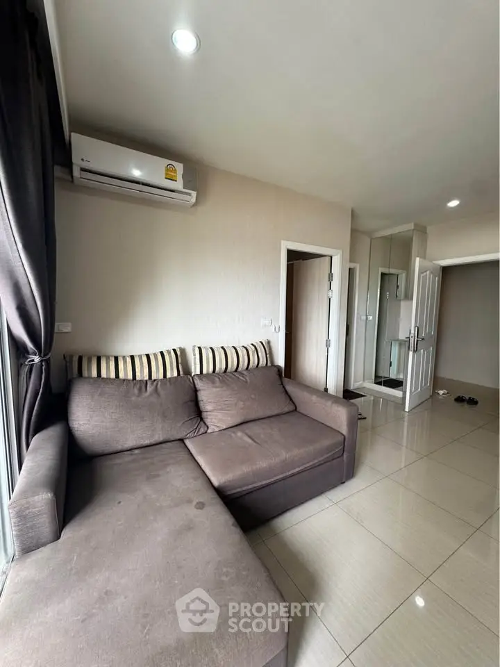 Modern living room with cozy sectional sofa and air conditioning in a stylish apartment.