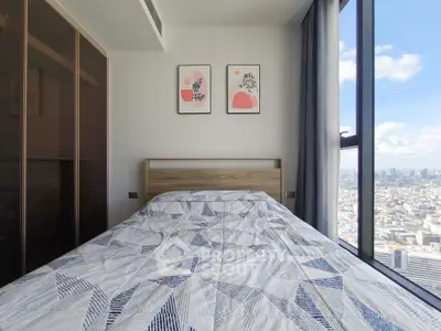 Modern bedroom with city view and stylish decor in high-rise apartment.