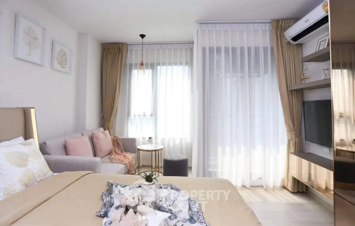 Modern bedroom with cozy decor, featuring a plush bed, stylish sofa, and elegant curtains.