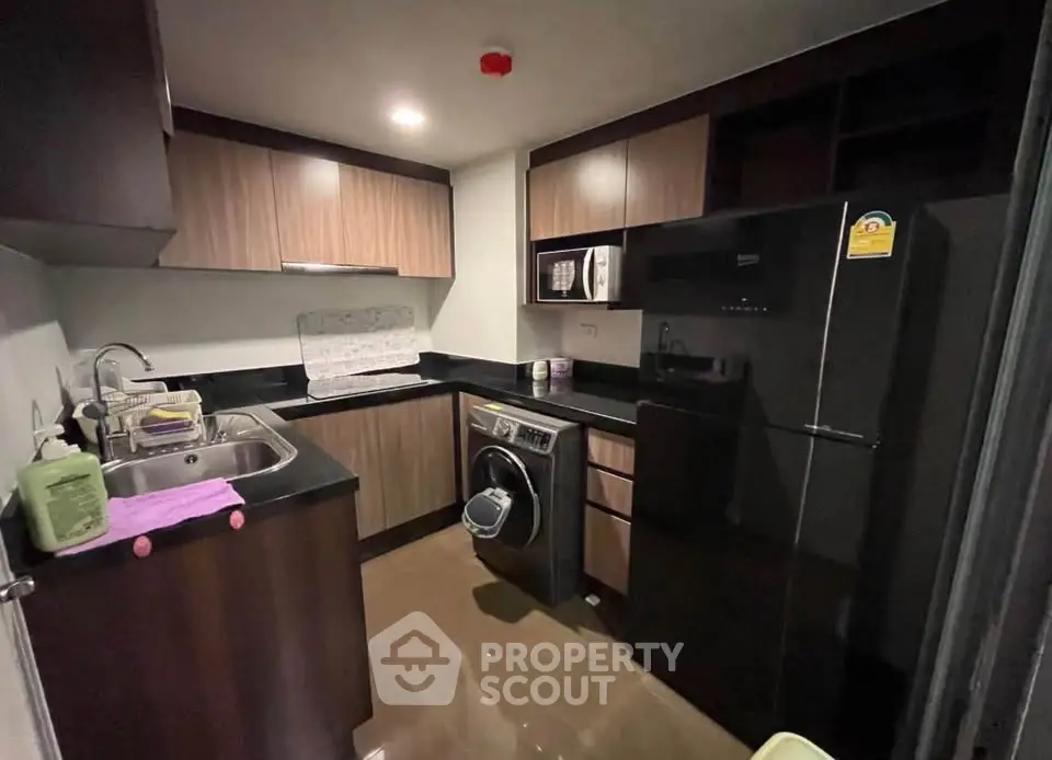 Modern kitchen with sleek appliances and ample storage in a cozy apartment setting.