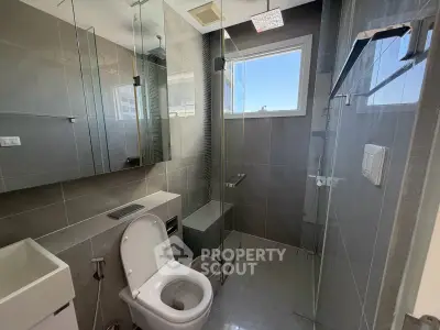 Modern bathroom with sleek glass shower and contemporary fixtures in a stylish apartment.