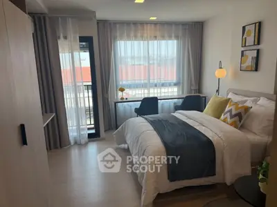 Modern bedroom with stylish decor and natural light, featuring a cozy bed and workspace.