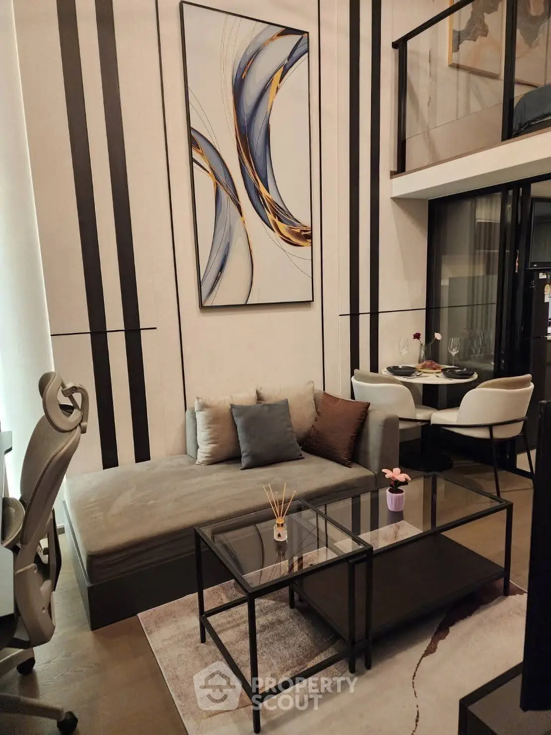 Modern living room with stylish decor and mezzanine level, featuring sleek furniture and contemporary artwork.