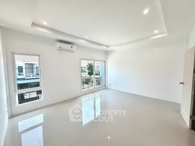 Spacious unfurnished living room with large windows and modern lighting
