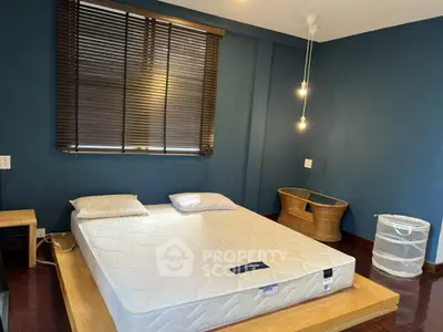 Spacious bedroom with modern design and cozy lighting, featuring a minimalist bed setup.