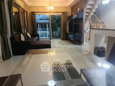 Spacious living room with modern decor and large windows leading to a balcony.