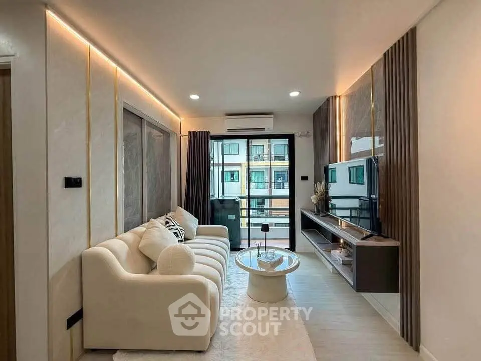 Modern living room with elegant decor and large windows offering natural light.