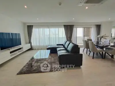 Spacious modern living room with sleek furniture and large windows for natural light.