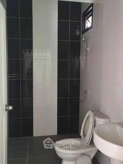 Modern bathroom with sleek black and white tiles and contemporary fixtures.