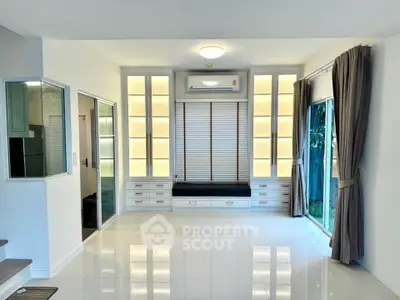 Spacious modern living room with large windows and built-in storage, perfect for natural light lovers.