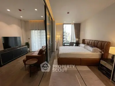 Luxurious modern bedroom with glass partition and city view, featuring elegant furnishings and natural light.