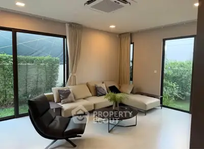 Modern living room with stylish furniture and garden view, perfect for relaxation and entertaining.