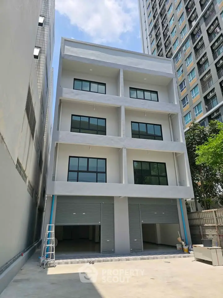 Modern multi-story building with large windows and garage doors, ideal for commercial use.