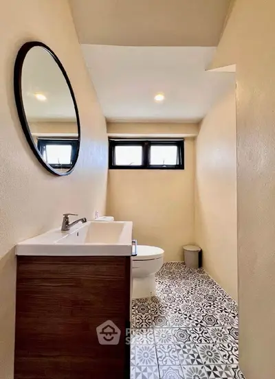 Chic bathroom with modern fixtures and patterned tile flooring, perfect for stylish urban living.