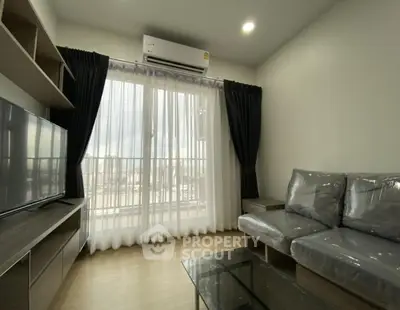 Modern living room with large window and sleek furniture in a cozy apartment.