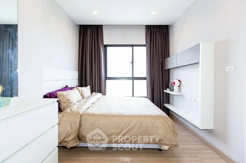 Modern bedroom with elegant decor and large window for natural light.