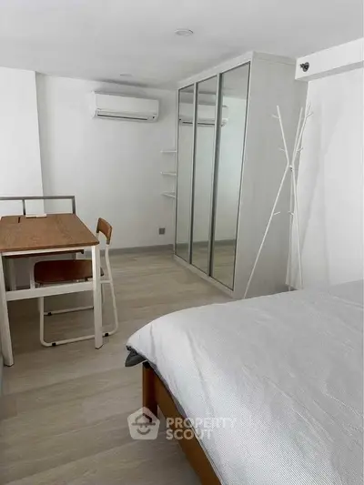 Modern bedroom with mirrored wardrobe and minimalist furniture