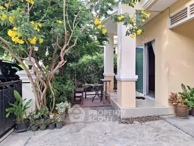 Charming garden patio with lush greenery and cozy seating area