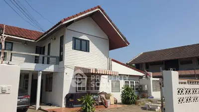 Charming two-story house with red roof and spacious driveway