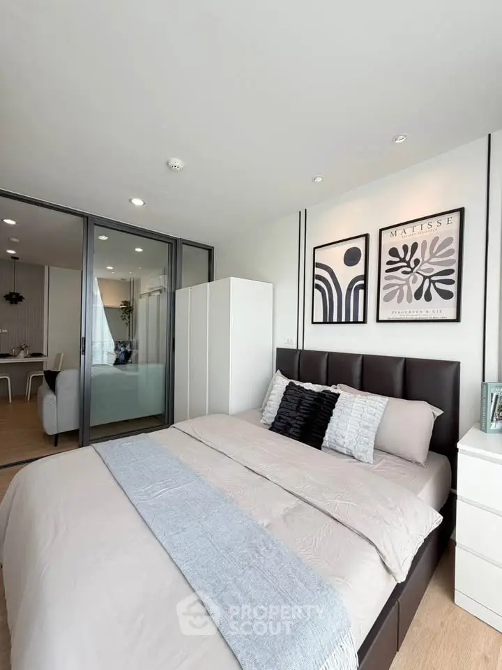 Modern bedroom with stylish decor and sliding glass doors leading to a cozy living area.