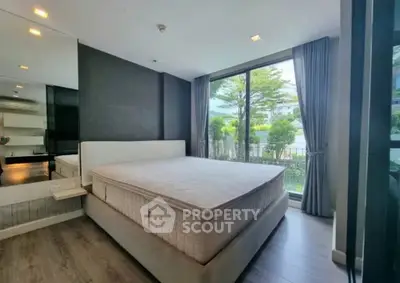 Spacious bedroom with large window and garden view in modern apartment