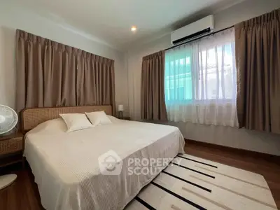 Spacious bedroom with large windows and modern air conditioning unit.