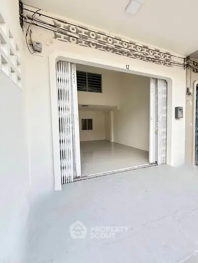 Spacious garage with white sliding doors and tiled flooring, perfect for storage or parking.