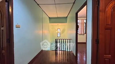 Charming hallway with wooden floors and elegant chandelier lighting