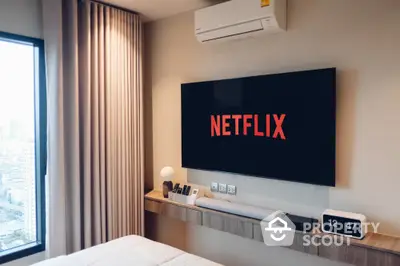 Modern bedroom with wall-mounted TV and city view window