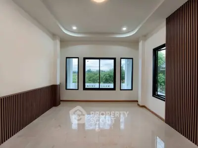Spacious modern living room with large windows and elegant wood paneling.