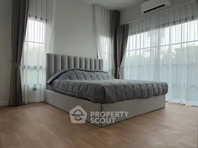 Modern bedroom with elegant gray bed and floor-to-ceiling windows