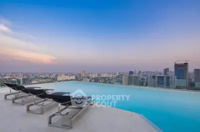 Stunning rooftop infinity pool with panoramic city skyline view at sunset.