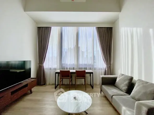 Modern living room with sleek furniture and large window for natural light.