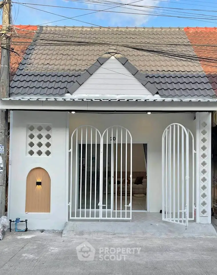 Charming single-story home with unique arched gates and modern facade, perfect for cozy living.