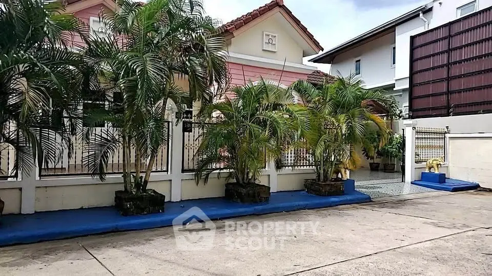 Charming suburban house with lush garden and secure gated entrance.