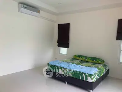 Spacious bedroom with modern air conditioning and stylish decor in a minimalist setting.