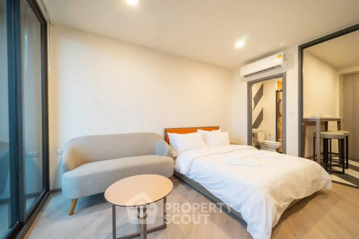 Modern studio apartment with cozy bed and stylish sofa in bright interior