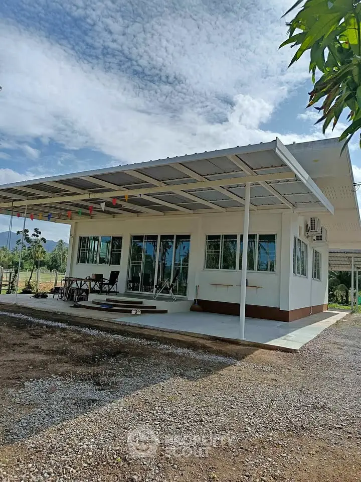 Charming modern house with spacious patio and large windows, perfect for enjoying scenic views and outdoor living.