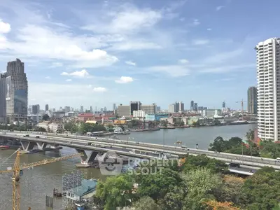 Stunning cityscape view with river and modern skyscrapers under a clear blue sky.