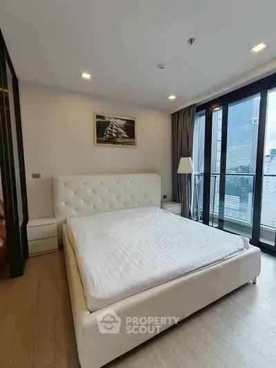 Spacious modern bedroom with large windows and city view in luxury apartment.