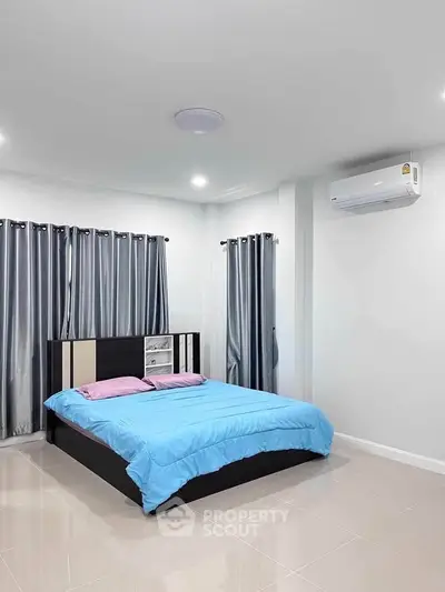 Modern bedroom with sleek design, featuring a comfortable bed and air conditioning.