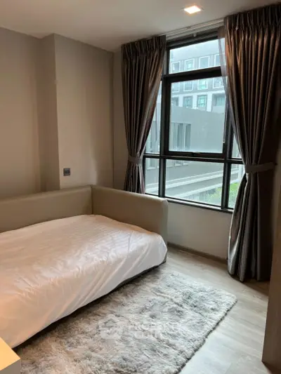 Cozy bedroom with large window and modern decor in urban apartment