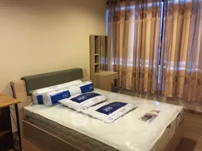 Cozy bedroom with natural light and modern furnishings in a stylish apartment.