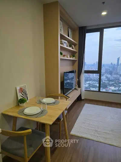 Modern living room with city view, featuring stylish furniture and built-in shelving.