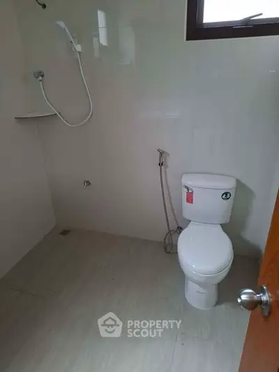 Modern bathroom with shower and toilet in a minimalist design.