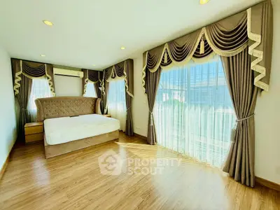 Spacious bedroom with elegant drapes and abundant natural light.